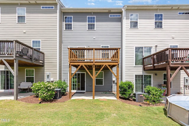 rear view of house with a patio area, a yard, a wooden deck, and central air condition unit
