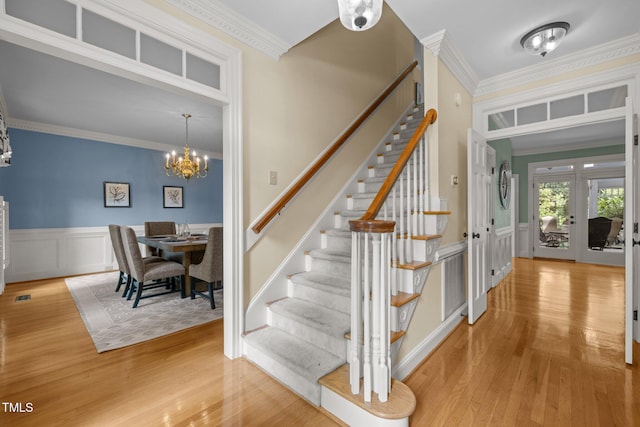 18 Acornridge Ct, Durham, NC 27707 - staircase with a chandelier, wood finished floors, crown molding, wainscoting, and french doors