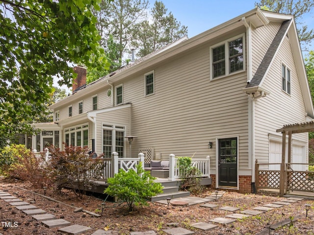 18 Acornridge Ct, Durham, NC 27707 - rear view of property with a chimney, a deck, and a garage
