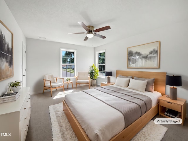 carpeted bedroom with ceiling fan and baseboards