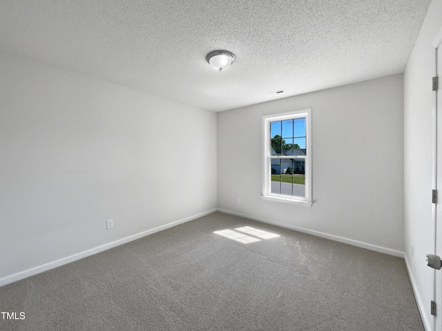 carpeted empty room with baseboards and a textured ceiling