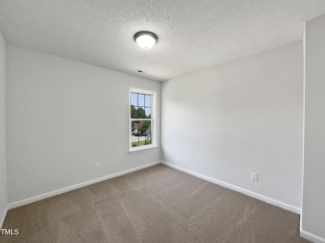 empty room featuring baseboards, carpet, and a textured ceiling