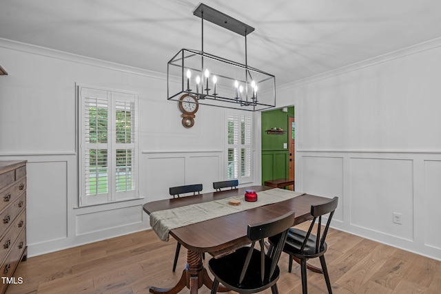 dining room with a decorative wall, ornamental molding, a chandelier, light wood finished floors, and healthy amount of natural light