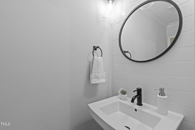 bathroom featuring a sink and tile walls