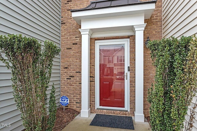 entrance to property featuring brick siding