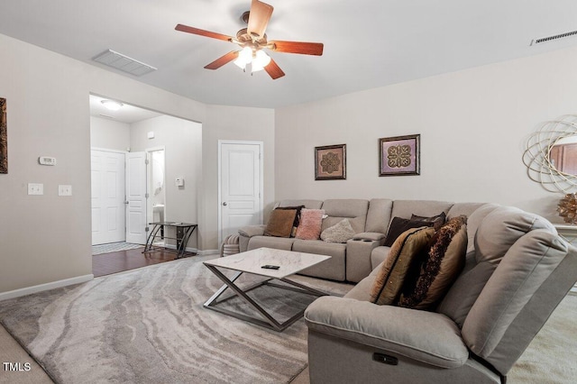 living room featuring a ceiling fan, carpet, and baseboards