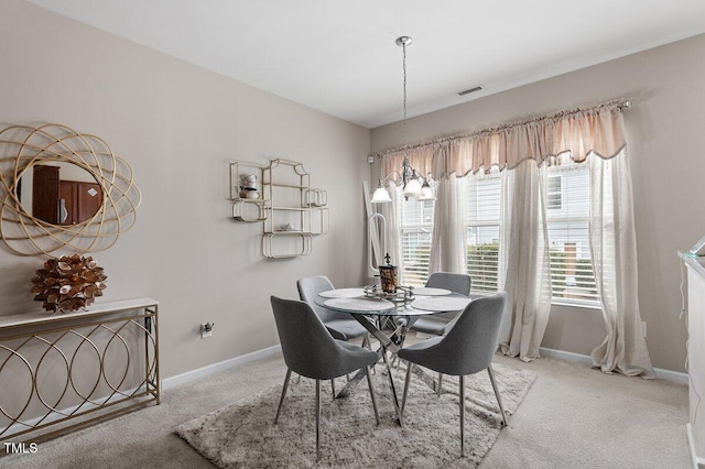 carpeted dining room featuring baseboards