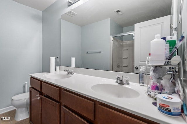 full bathroom featuring toilet, a tile shower, double vanity, and tile patterned floors