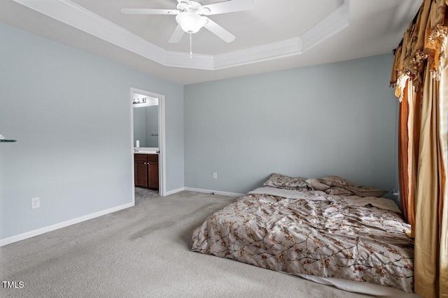 bedroom featuring carpet flooring, a tray ceiling, ornamental molding, connected bathroom, and baseboards