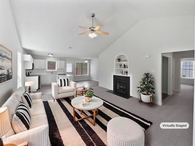 5612 Tealbrook Dr, Raleigh, NC 27610 - living room featuring built in features, ceiling fan, plenty of natural light, a fireplace with flush hearth, and high vaulted ceiling