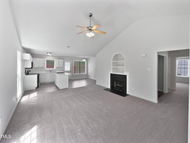 5612 Tealbrook Dr, Raleigh, NC 27610 - unfurnished living room with light carpet, baseboards, ceiling fan, built in shelves, and a fireplace with flush hearth