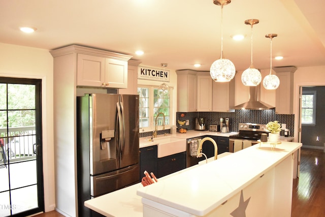 3141 Wagoner Ln Unit 09, Graham, NC 27253 - kitchen featuring stainless steel appliances, wall chimney range hood, a sink, tasteful backsplash, and dark wood-type flooring