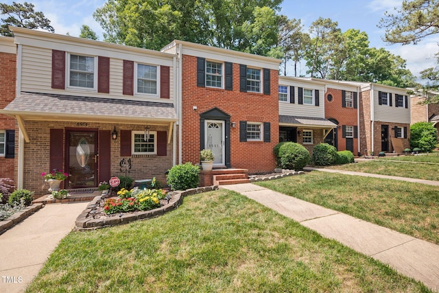 view of front of house with a front lawn and brick siding