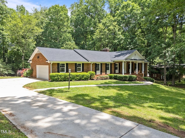 3204 Manor Ridge Dr, Raleigh, NC 27603 - view of front of home with a porch, brick siding, a front lawn, an attached garage, and concrete driveway