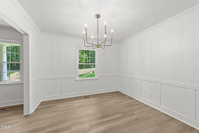 3204 Manor Ridge Dr, Raleigh, NC 27603 - unfurnished room with a chandelier, crown molding, wainscoting, light wood-type flooring, and a decorative wall