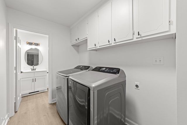 3204 Manor Ridge Dr, Raleigh, NC 27603 - laundry room with cabinet space, light wood finished floors, washing machine and clothes dryer, and baseboards
