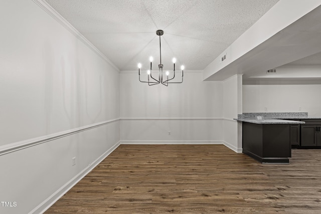 3204 Manor Ridge Dr, Raleigh, NC 27603 - unfurnished dining area with dark wood-type flooring, a textured ceiling, a chandelier, crown molding, and baseboards