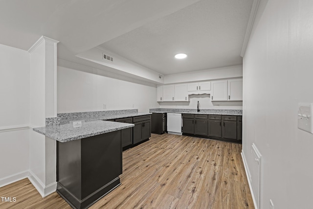 3204 Manor Ridge Dr, Raleigh, NC 27603 - kitchen featuring white dishwasher, a peninsula, light wood-style floors, light stone counters, and white cabinets