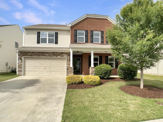view of front of home featuring concrete driveway, a front lawn, an attached garage, covered porch, and stone siding