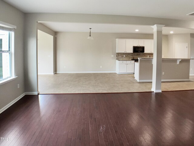 unfurnished living room featuring light wood-style flooring, baseboards, and recessed lighting