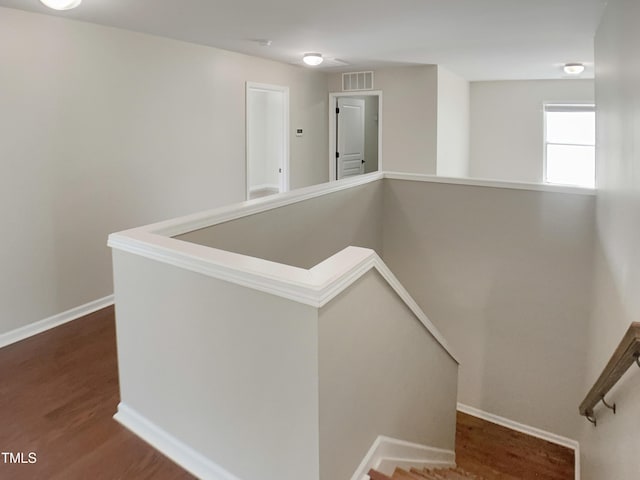 staircase featuring wood finished floors and baseboards