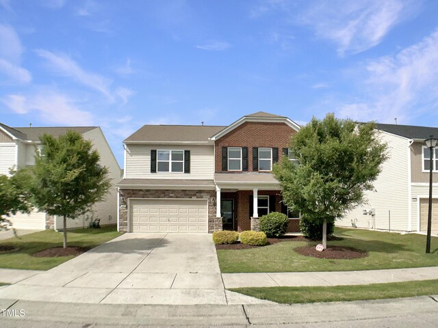view of front of property with concrete driveway, a garage, a front lawn, a porch, and stone siding