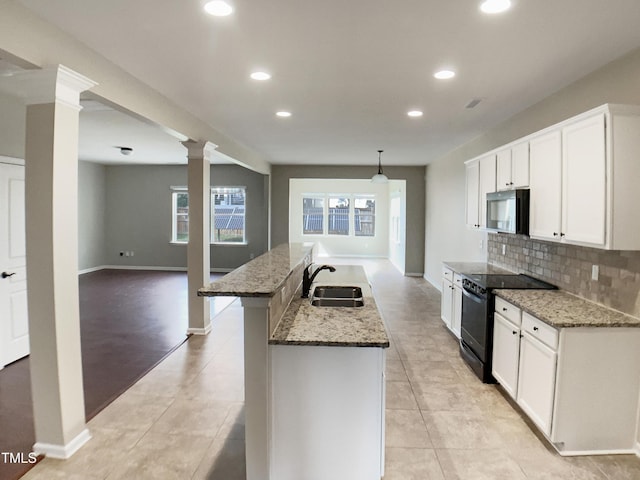 kitchen featuring black range with electric stovetop, stainless steel microwave, a sink, recessed lighting, and backsplash