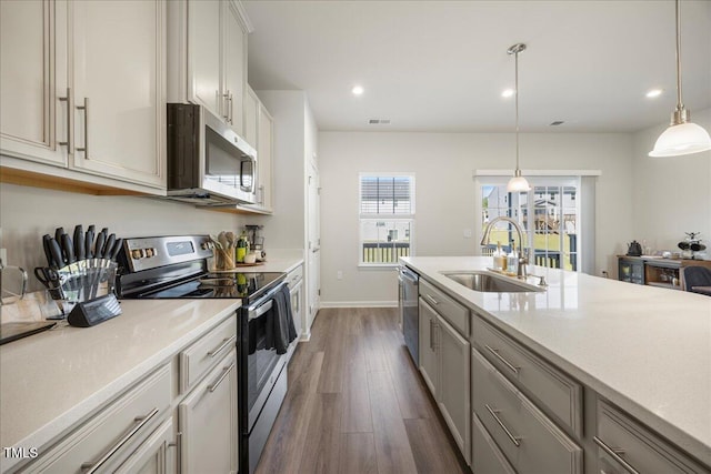 926 Romeria Dr, Durham, NC 27713 - kitchen featuring stainless steel appliances, a sink, dark wood finished floors, recessed lighting, and decorative light fixtures
