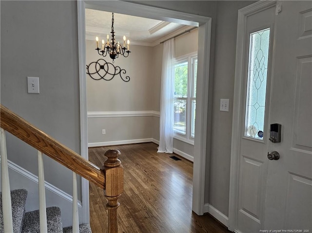 entrance foyer with baseboards, dark wood-style flooring, a chandelier, crown molding, and stairway