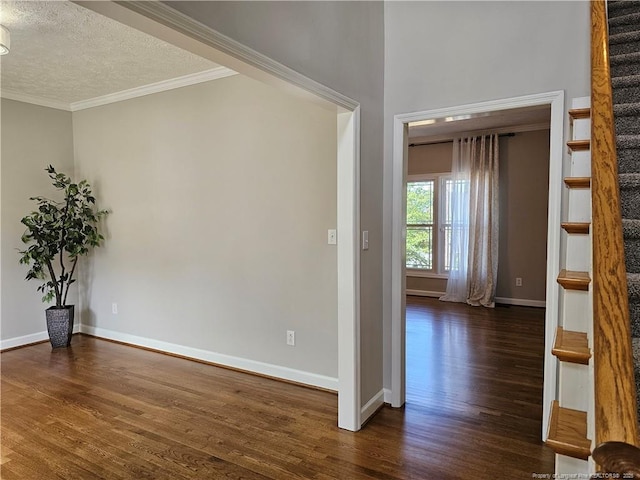 unfurnished room featuring dark wood-style flooring, ornamental molding, baseboards, stairs, and a textured ceiling