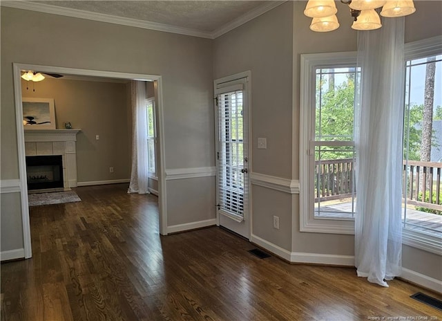 entryway featuring healthy amount of natural light, dark wood-style floors, crown molding, and baseboards