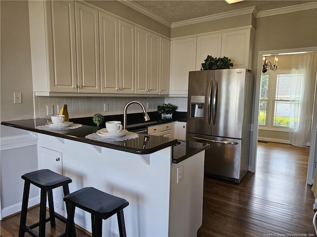 kitchen featuring stainless steel fridge, backsplash, a peninsula, white cabinets, and dark wood finished floors