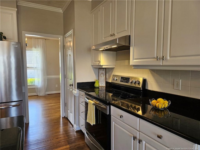 kitchen featuring appliances with stainless steel finishes, under cabinet range hood, ornamental molding, tasteful backsplash, and dark wood-style flooring
