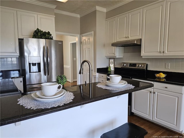 kitchen with stainless steel appliances, under cabinet range hood, white cabinetry, backsplash, and crown molding