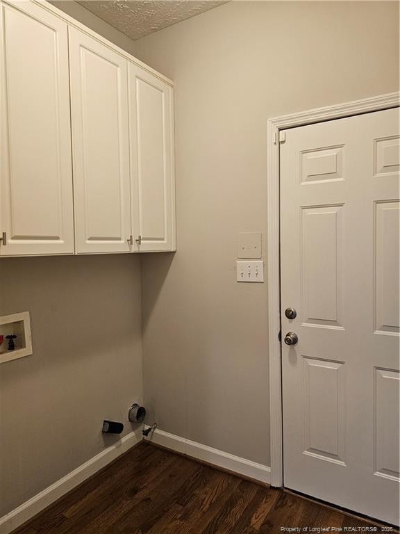 washroom featuring cabinet space, dark wood-type flooring, baseboards, and hookup for a washing machine