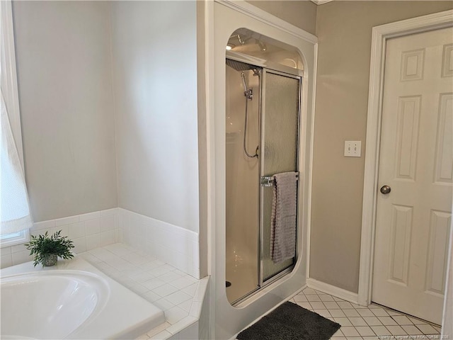 full bath featuring a stall shower, a garden tub, and tile patterned floors