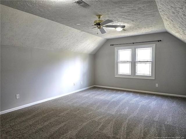 bonus room featuring a textured ceiling, lofted ceiling, baseboards, carpet, and a ceiling fan
