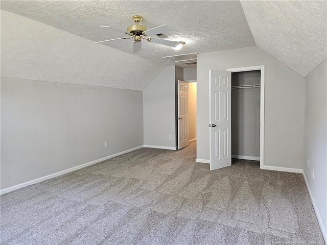 bonus room featuring a textured ceiling, carpet floors, a ceiling fan, lofted ceiling, and baseboards
