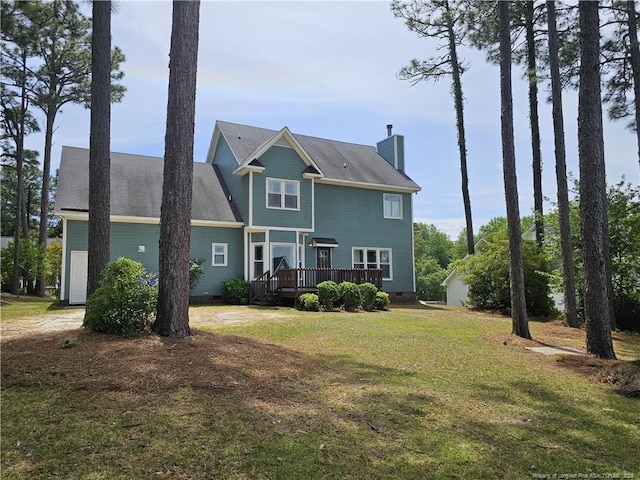 back of property featuring a chimney, a wooden deck, a yard, and crawl space
