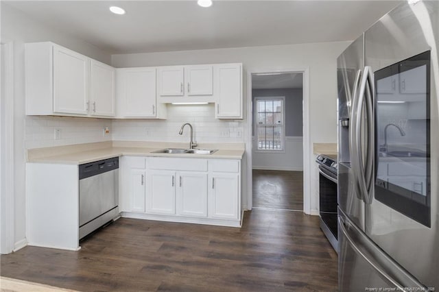 kitchen with stainless steel appliances, white cabinets, light countertops, a sink, and recessed lighting