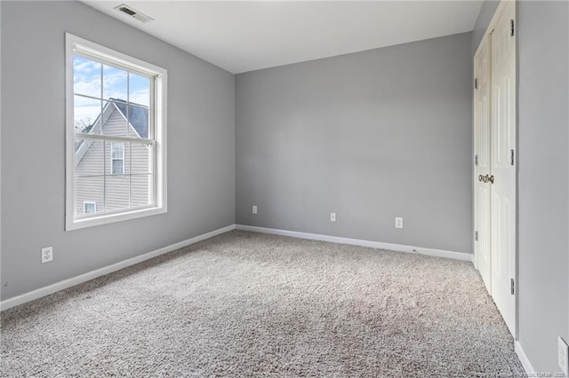empty room with baseboards and carpet
