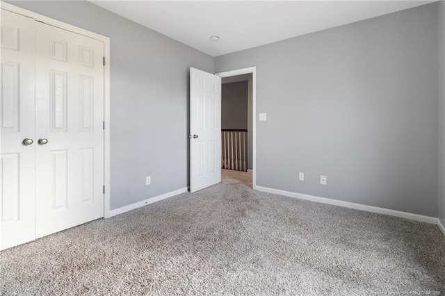 unfurnished bedroom featuring carpet floors, baseboards, and a closet
