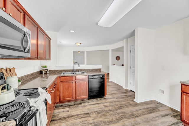 kitchen featuring stainless steel microwave, a sink, black dishwasher, light wood-style flooring, and electric range