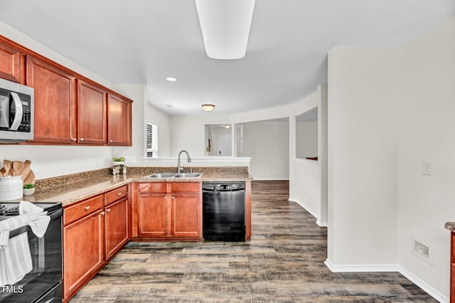 kitchen with black appliances, a sink, dark wood-style floors, a peninsula, and recessed lighting