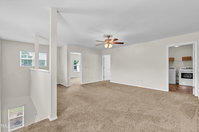 unfurnished living room with washing machine and dryer, carpet, plenty of natural light, and baseboards