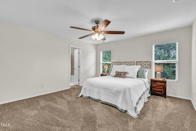 carpeted bedroom featuring baseboards, ceiling fan, and connected bathroom