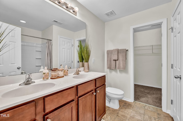 full bathroom with toilet, double vanity, baseboards, curtained shower, and a walk in closet