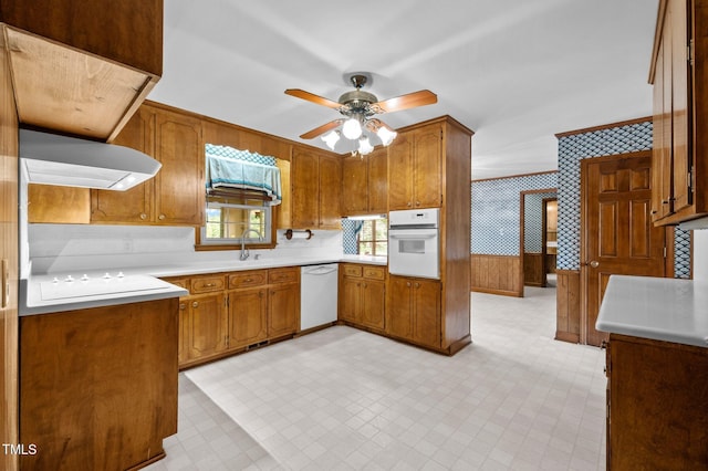913 Milton Rd, Durham, NC 27712 - kitchen with white appliances, wallpapered walls, wall chimney range hood, ceiling fan, and brown cabinets