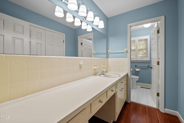 913 Milton Rd, Durham, NC 27712 - bathroom featuring vanity, wood finished floors, and backsplash