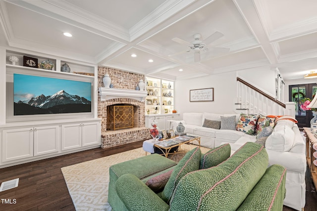 living area featuring coffered ceiling, dark wood-style flooring, stairway, ceiling fan, and ornamental molding